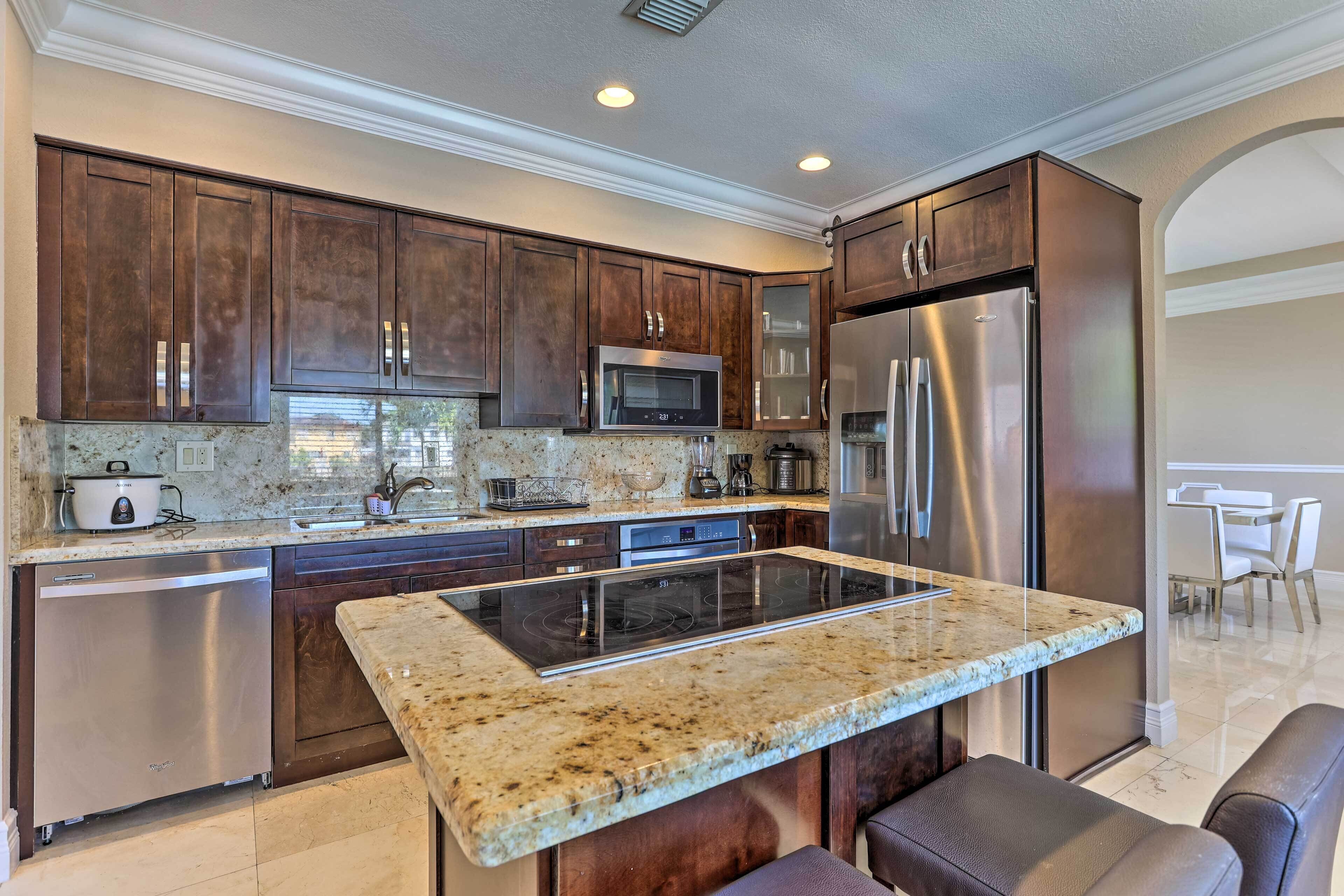 A modern kitchen with dark wood cabinets, stainless steel appliances, and a granite countertop.