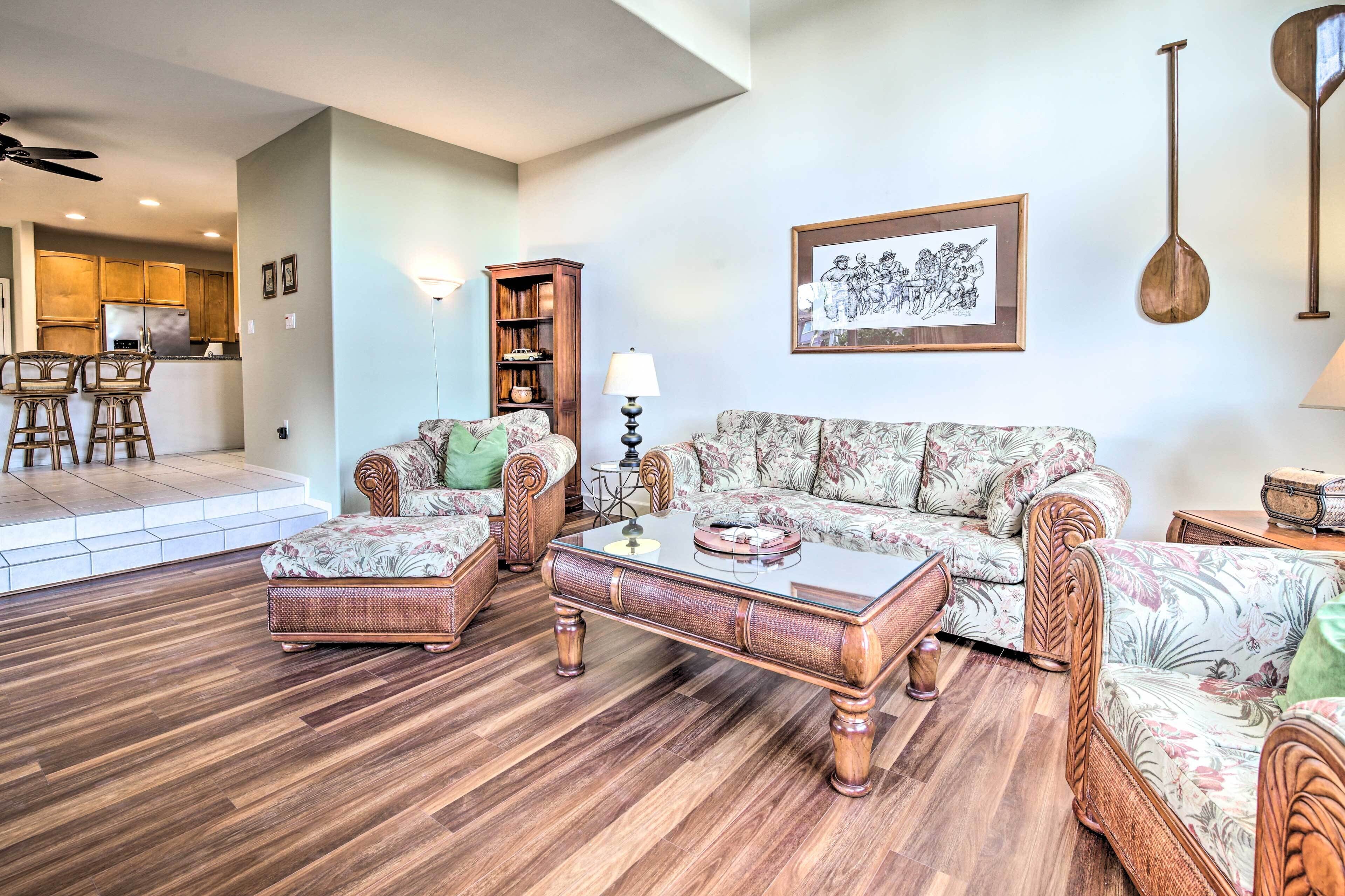 A living room with a sofa, two armchairs, a coffee table, and a bookshelf.