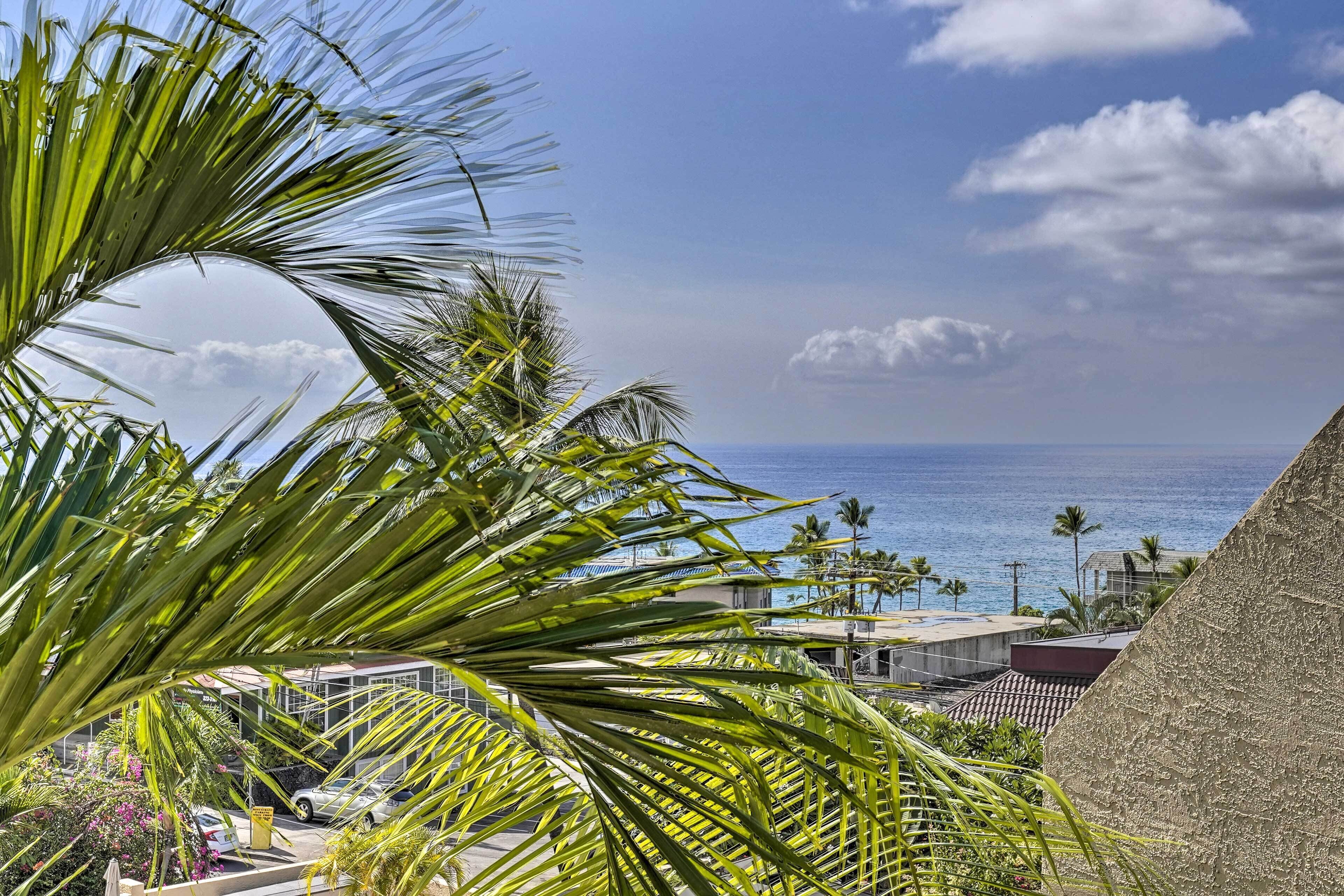 Vista sulla costa con palme, cielo sereno e oceano.