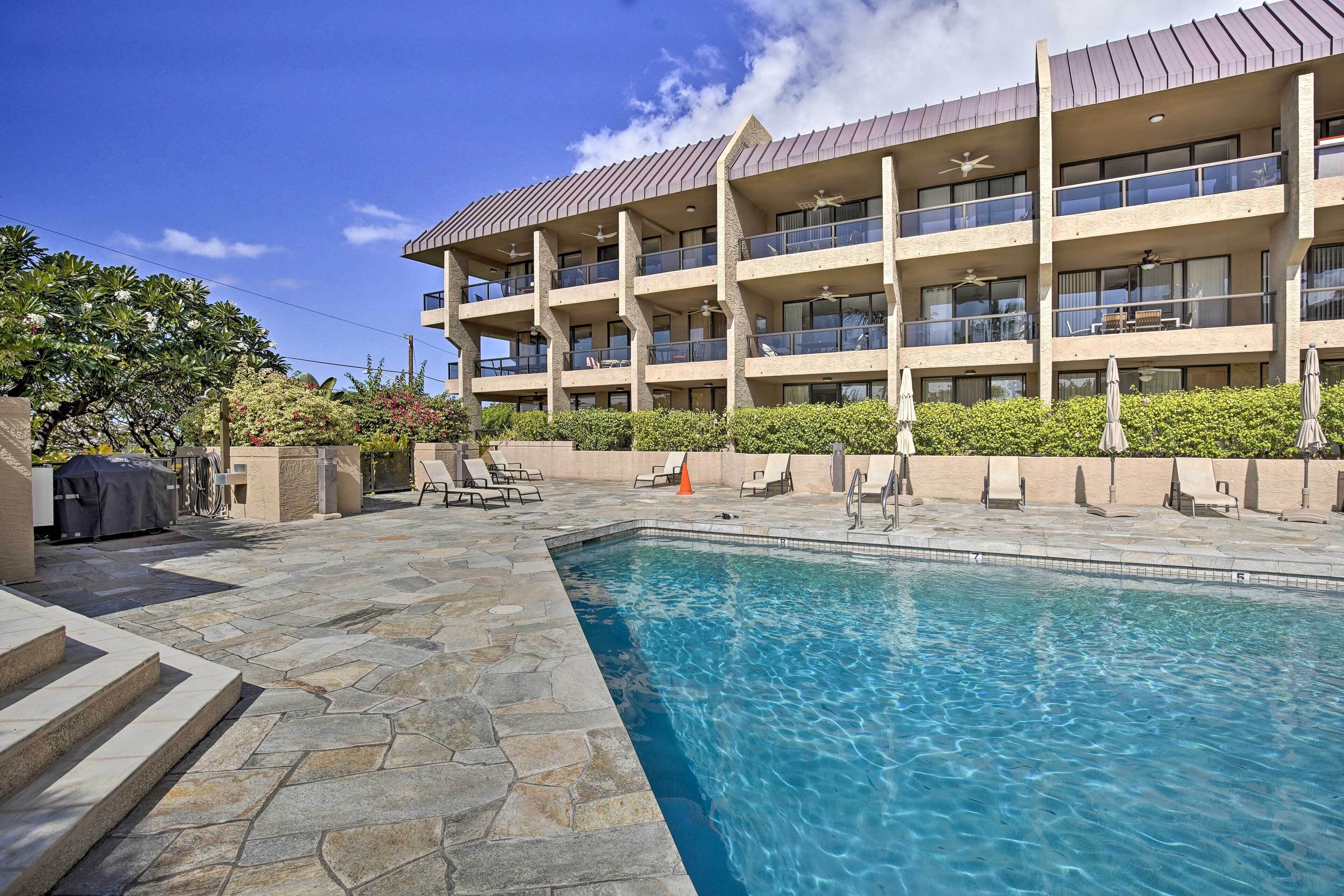 A hotel with a swimming pool, outdoor seating, and a multi-story building with balconies.