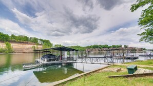 Un muelle junto al lago con zona de estar cubierta y rampa para embarcaciones.