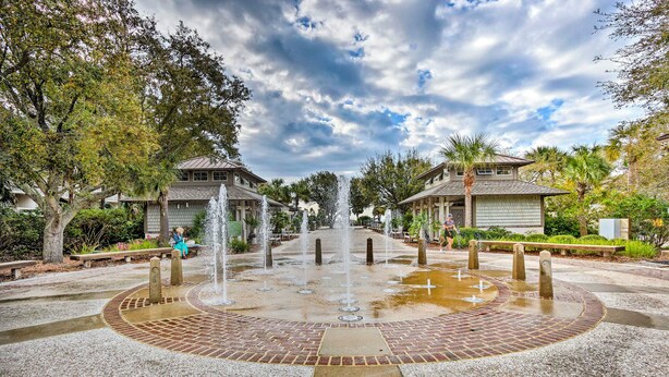 A courtyard with a central fountain, surrounded by brick pathways and palm trees. - Ocean Views + Pool Access: Hilton Head Getaway (Hilton Head Island)