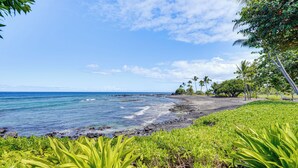 A coastal landscape with a clear view of the ocean, a rocky shoreline, and lush greenery. - Ultimate Oceanfront Townhome w/ A/C On Kona Coast (Kailua-Kona)