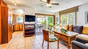 A spacious living area with a dining table, sofa, and a ceiling fan. - Ultimate Oceanfront Townhome w/ A/C On Kona Coast (Kailua-Kona)