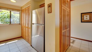 A kitchen with a refrigerator, wooden cabinets, and a window with blinds. - Kailua-kona Condo w/ Resort Access & Ocean View! (Kailua-Kona)