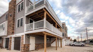 A two-story house with a balcony, a garage, and a driveway.