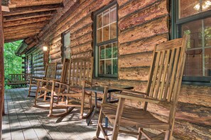 A log cabin with a porch featuring wooden rocking chairs and a glass door. - Secluded Cabin w/ Spacious Kitchen & Dining Area! (Pickens)