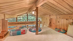 A cozy attic bedroom with a wooden ceiling, a large window, and a view of the outdoors. - High Falls Restorative Cabin in the Woods! (High Falls)