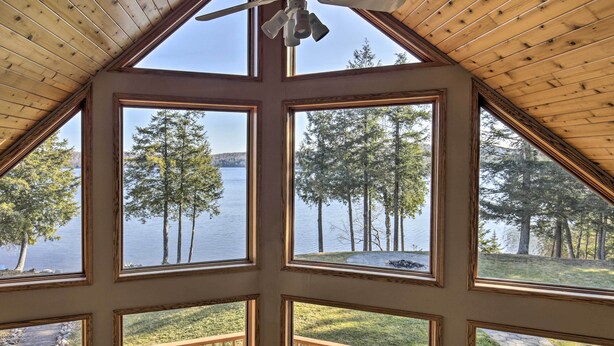 A room with large windows offering views of a lake and trees. - Secluded Lakehouse w/ Private Dock + Serene Views! (Iron River)