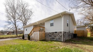 Une maison de plain-pied avec des fondations en pierre et une terrasse en bois.