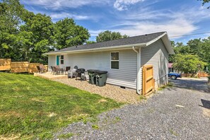 Einbungalow mit Veranda, kleiner Terrasse und Auffahrt mit Kies.