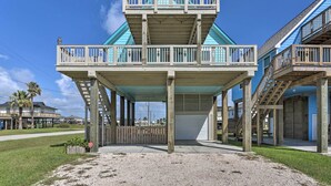Une construction en bois à deux étages, dotée d’un balcon, d’une entrée couverte et d’un garage.