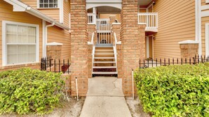 A two-story building with a central staircase leading to a balcony.