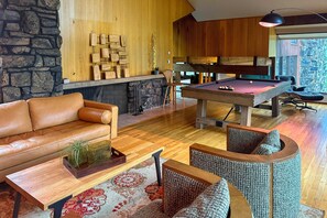 A cozy living room with a pool table, leather sofa, and a wooden coffee table with a plant. - Chic Boulder Mountain Home w/ Hot Tub + Views (Boulder)
