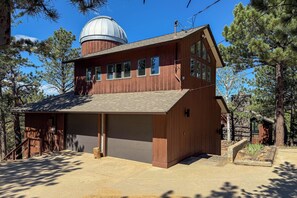 A wooden cabin with a large dome structure, a garage, and a covered porch area. - Chic Boulder Mountain Home w/ Hot Tub + Views (Boulder)