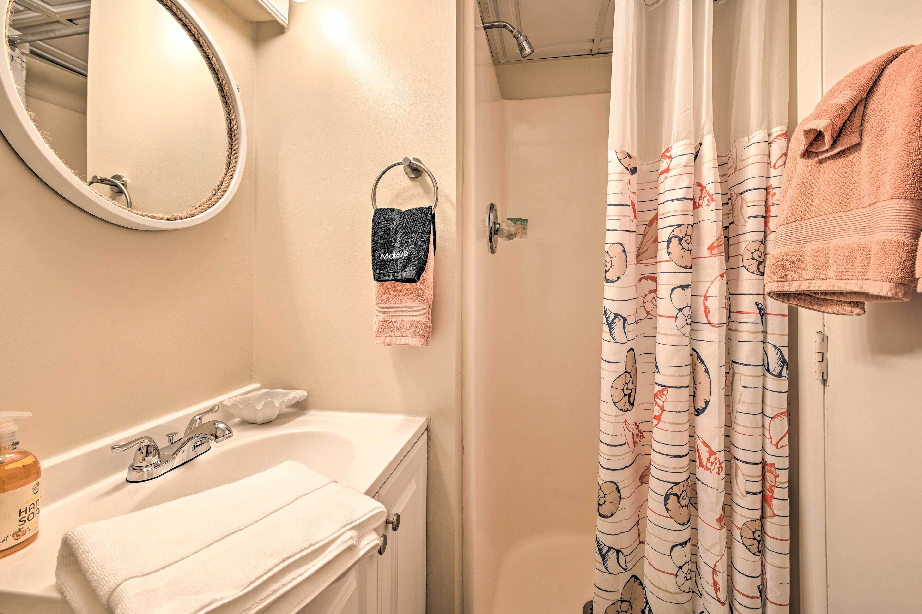 A bathroom with a bathtub, a sink, a mirror, and a shower curtain.