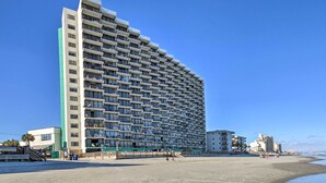 A large hotel with multiple floors and balconies, situated on a beach with a clear sky. - Oceanfront Oasis w/ Deck and Resort Beach Access! (Murrells Inlet)