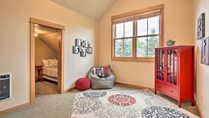 A room with a large window, a red cabinet, a patterned rug, and a wall with number decorations.
