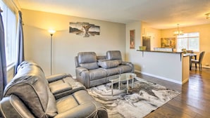 A living room with a sectional sofa, a glass coffee table, and a marble rug. - Charming Columbus Home ~ 7 Mi to Ohio State! (Columbus)
