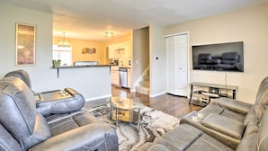 A living room with leather sofas, a glass coffee table, and a TV on the wall. - Charming Columbus Home ~ 7 Mi to Ohio State! (Columbus)