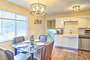A modern kitchen with white cabinets, a stainless steel dishwasher, and a coffee maker.