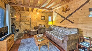 A cozy log cabin interior with a fireplace, wooden furniture, and a rustic decor. - Secluded Johnsburg Retreat w/ Hot Tub & Fire Pit (Johnsburg)