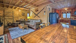 A rustic wooden interior with a large dining table, a sofa, and a kitchen area. - Secluded Johnsburg Retreat w/ Hot Tub & Fire Pit (Johnsburg)