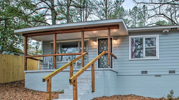 A house with a wooden staircase leading to a covered porch.