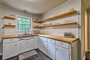 A kitchen with white cabinets, wooden countertops, and a window. - Centrally Located Hot Springs Home w/ Deck! (Hot Springs)