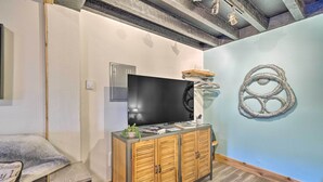 Una stanza con un armadio in legno, una televisione a schermo piatto e un elemento decorativo a parete.