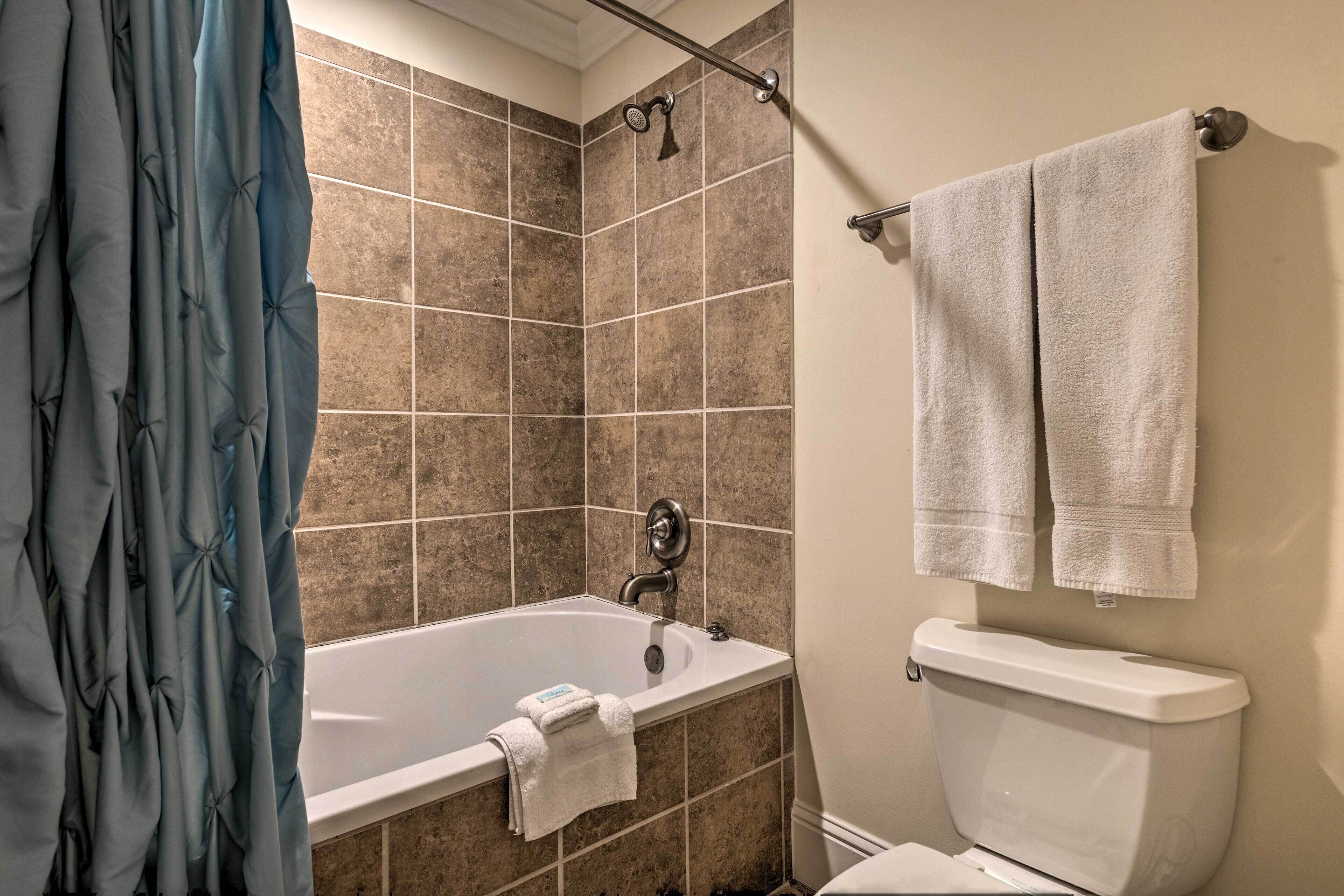 Un baño con bañera, ducha y retrete.