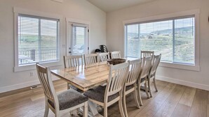 A dining room with a wooden table and six chairs, large windows with blinds, and a ceiling vent. - Garden City Retreat w/ Access to Bear Lake! (Garden City)