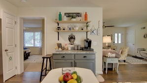 A kitchen with a central island, a coffee machine, and a fruit bowl. There are shelves above the island with various items and a sign that says "FRESH HER". - Ocean View Escape ~ 4 Miles to Bethany Beach! (Ocean View)