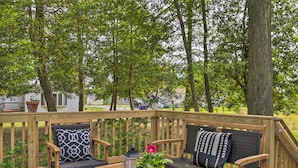A wooden deck with a sofa and chairs, a table, and a potted plant with flowers. - Ocean View Escape ~ 4 Miles to Bethany Beach! (Ocean View)