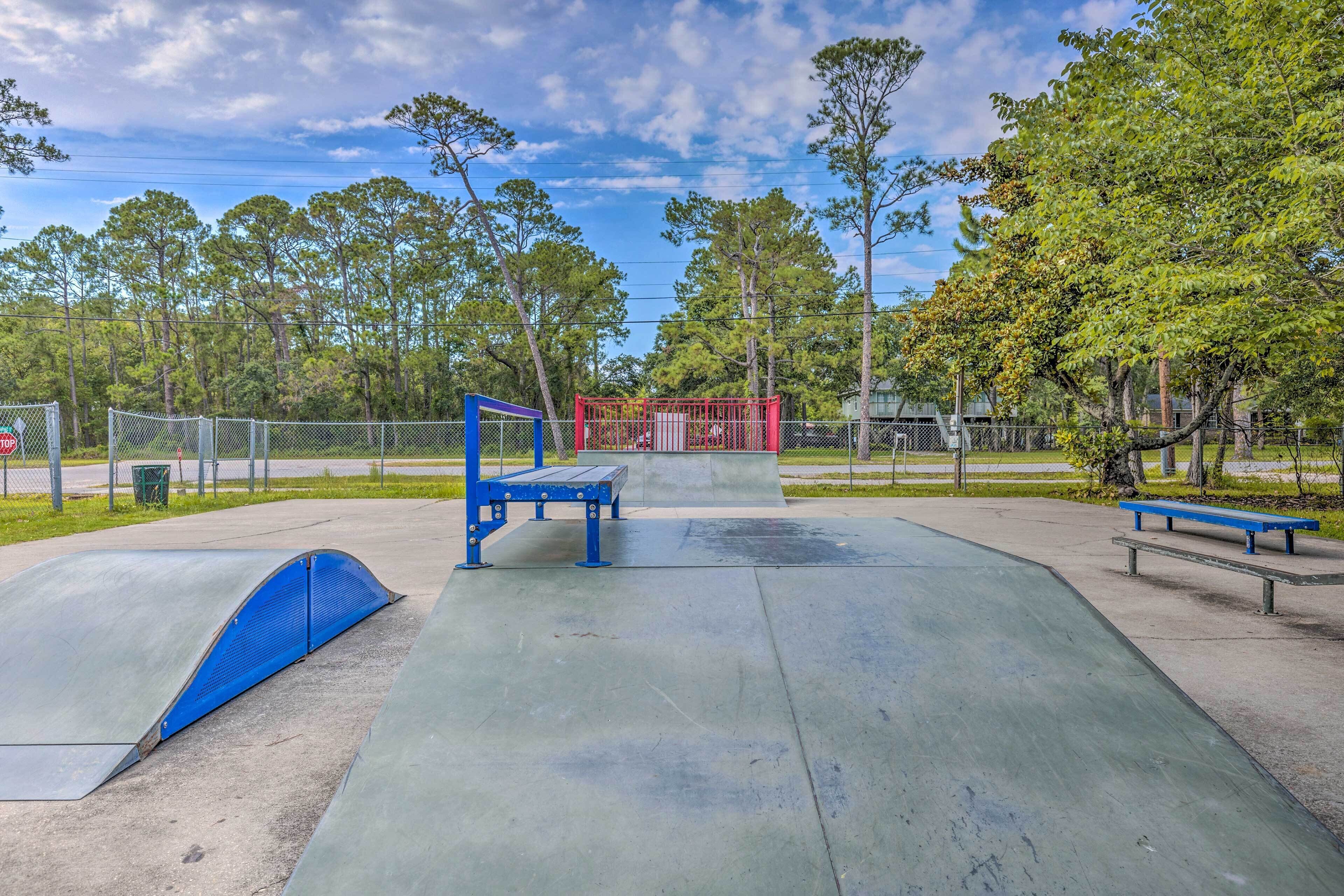 A skate park with ramps, benches, and a fenced area.