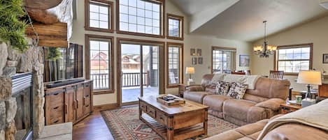 A spacious living room with a fireplace, large windows, and a cozy seating area.