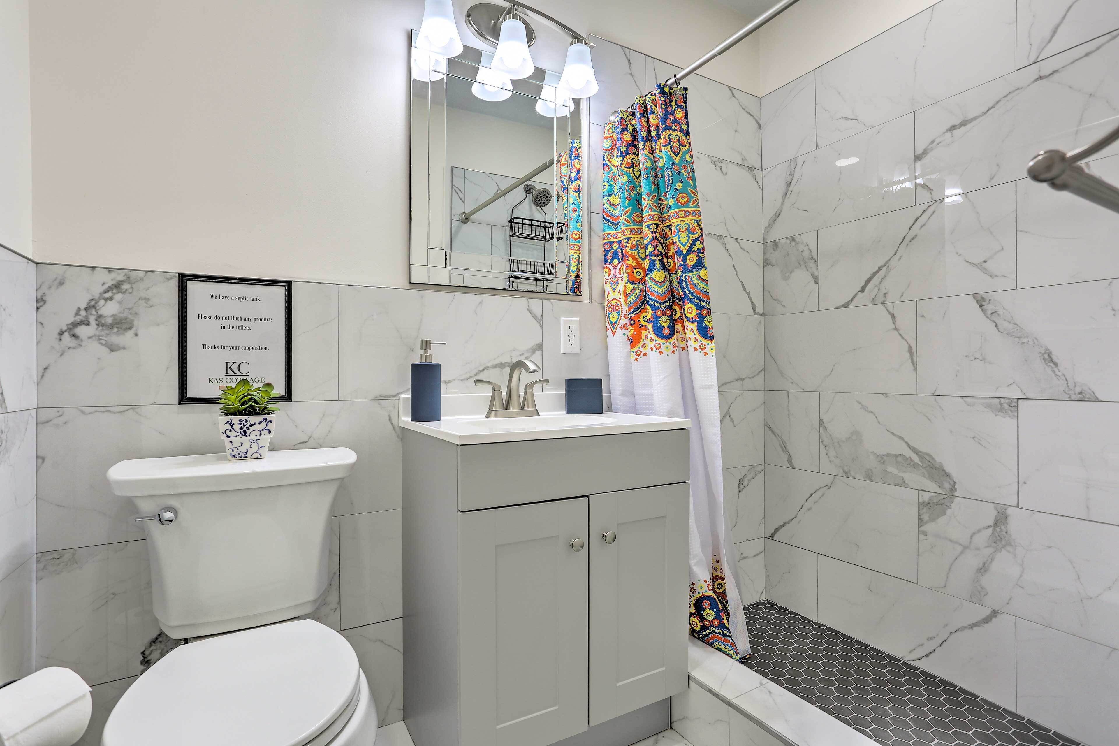 Un bagno moderno con il water, lavandino e doccia.