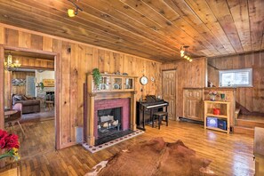A rustic interior with a fireplace, piano, and wooden walls. - Remodeled Lake Cabin, Stunning Mtn View, New Patio (Twin Lakes)