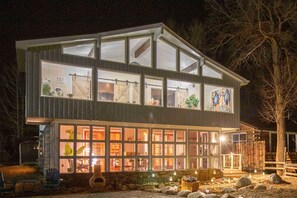 A two-story building with large windows and a stone foundation. - Remodeled Lake Cabin, Stunning Mtn View, New Patio (Twin Lakes)