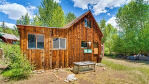 A rustic wooden cabin with a sloped roof, large windows, and a small porch area. - Remodeled Lake Cabin, Stunning Mtn View, New Patio (Twin Lakes)