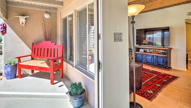 A living room with a red bench, a TV, and a wooden cabinet. - Traditional-style Adobe Casita - Walk to Dtwn (Santa Fe)