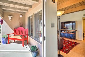 Un salon avec un banc rouge, un téléviseur et un meuble en bois.