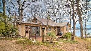 A cabin with a wooden exterior, large windows, and a deck. - Authentic Retreat w/ Private Dock on Coosa River! (Shelby)