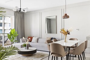 A modern living room with a sofa, dining table, chairs, and a large mirror. - Silkhaus Boulevard Central, Downtown Dubai (Dubai)