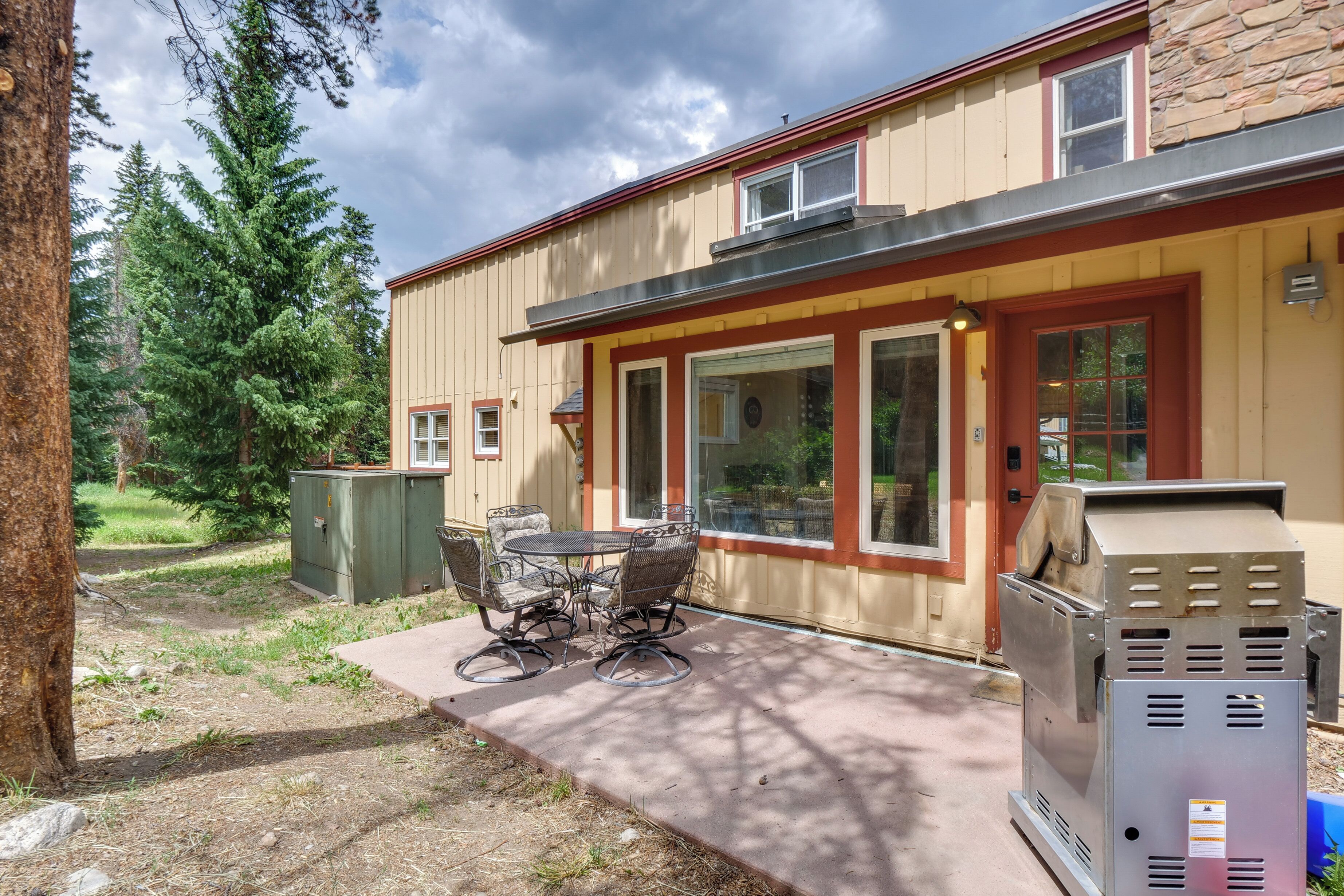 A patio with outdoor furniture, a grill, and a utility box.