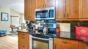 Una cocina moderna con armarios de madera, electrodomésticos de acero inoxidable y una encimera negra.