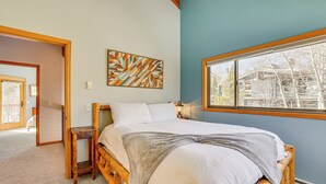 A bedroom with a wooden bed, a window with a view of buildings, and a wall-mounted abstract art piece. - 10 Mi to Keystone Resort: Cabin w/ Private Hot Tub (Silverthorne)