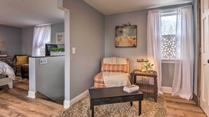 A cozy bedroom with a bed, a bedside table, a small rug, and a window with curtains. - Secluded Lothian Farmhouse on 45 Acres w/ Fire Pit (Lothian)