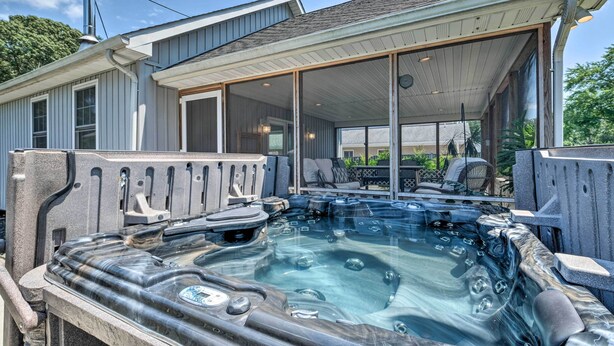 A hot tub area with a covered patio, stone seating, and a view of the backyard. - Idyllic Pasadena Retreat With Garden + Hot Tub! (Pasadena)
