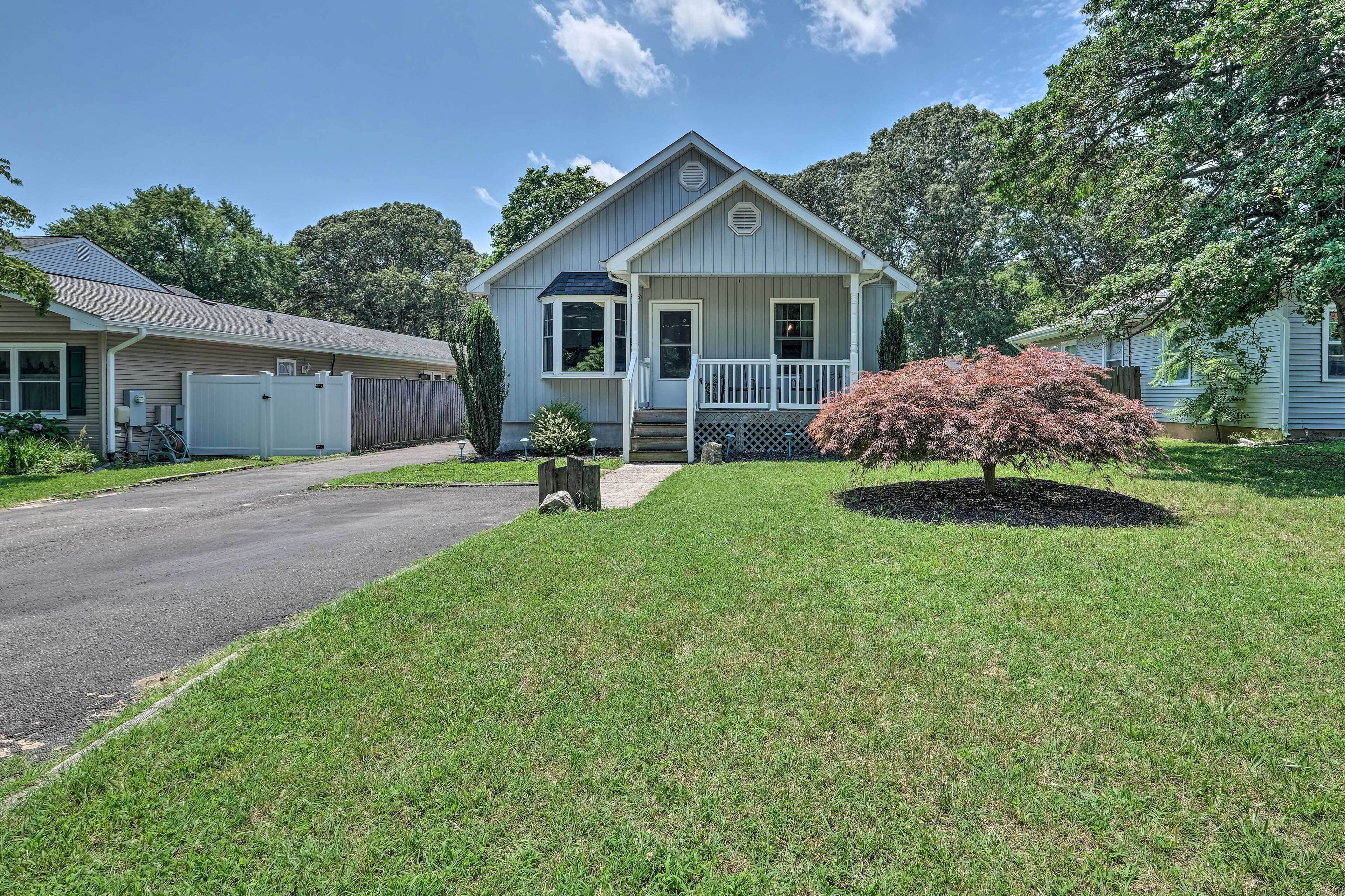 A single-story house with a front porch, a small garden, and a driveway.
